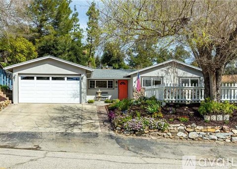 A house with a garage and a porch with a flag on it.