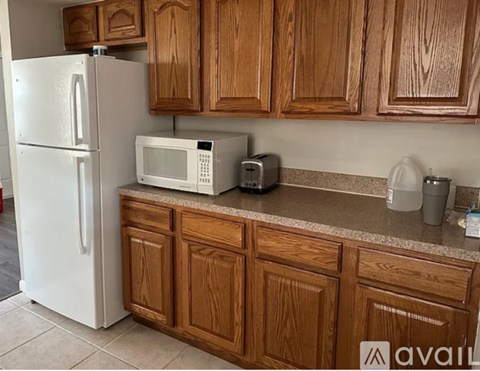A kitchen with wooden cabinets and a white refrigerator.