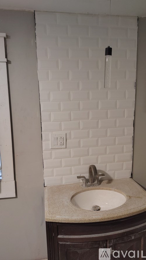 A kitchen with white cabinets and a granite countertop is available for rent.