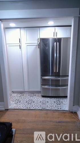 A room with wooden flooring and white walls.