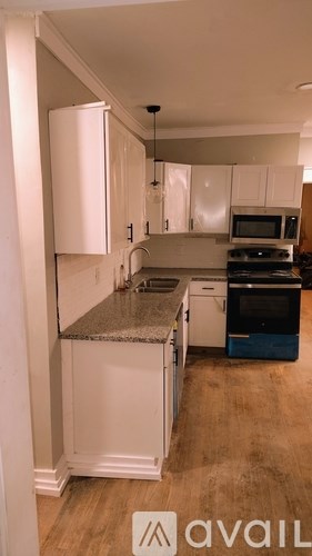 A kitchen with white cabinets and a granite countertop.