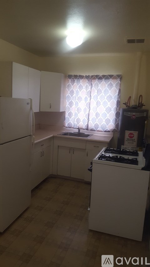 A kitchen with white appliances and cabinets.