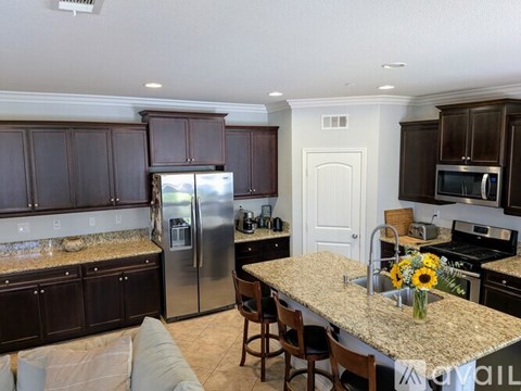 A kitchen with brown cabinets and granite countertops.