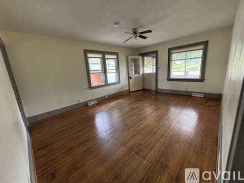 A room with wooden flooring and a ceiling fan.