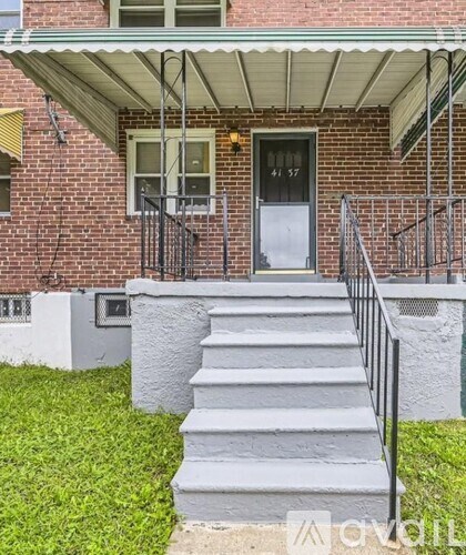 A red brick house with a grey front porch and steps.