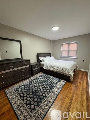 A bedroom with a bed, dresser, and mirror.