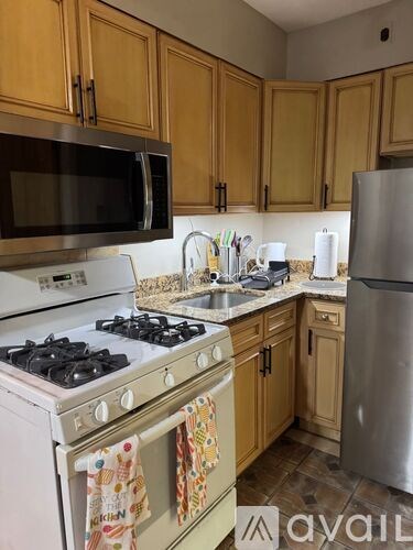 A kitchen with wooden cabinets and a stove top oven.