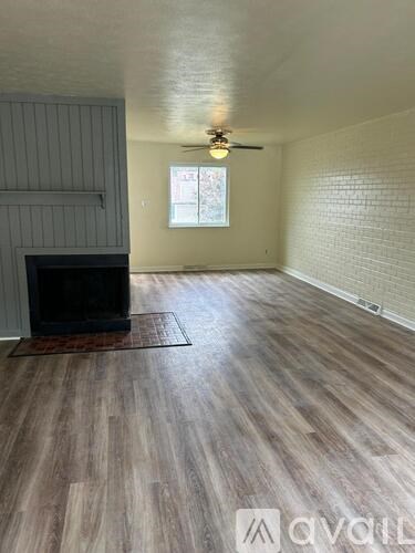 A room with wooden flooring and a window letting in natural light.