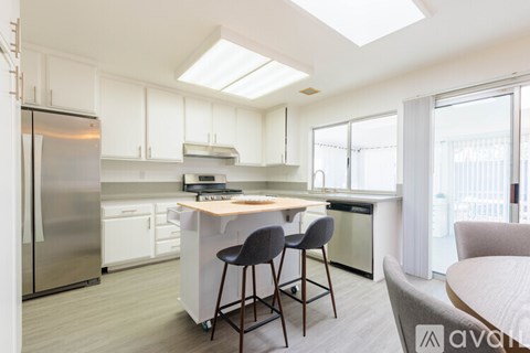 A modern kitchen with white cabinets and a central island.