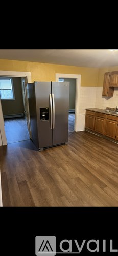 A kitchen with a refrigerator and wooden cabinets.
