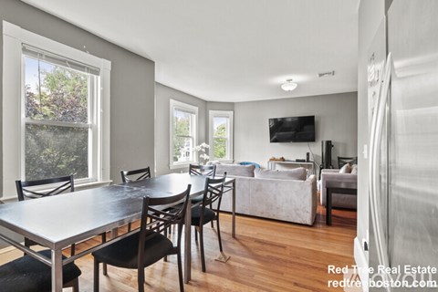 A living room with a dining table and chairs.