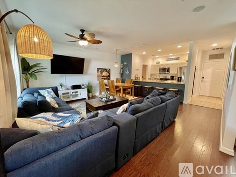 A living room with a grey couch and a wooden floor.