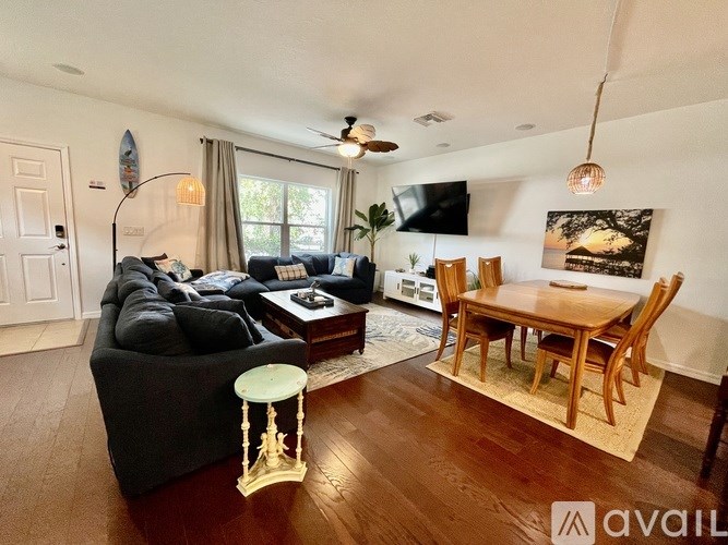 A living room with a grey couch, a wooden table, and a television.