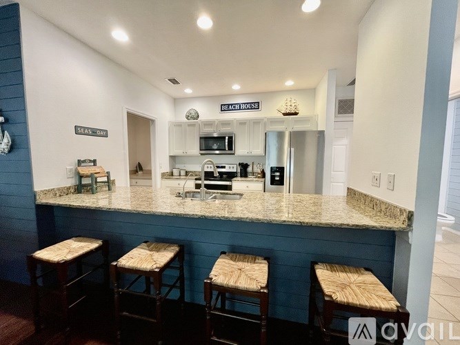 A kitchen with a bar area and four stools.