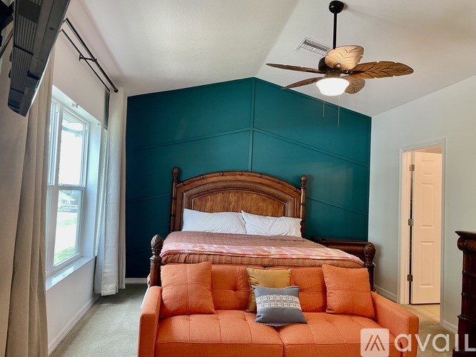 A bedroom with a bed and a ceiling fan.
