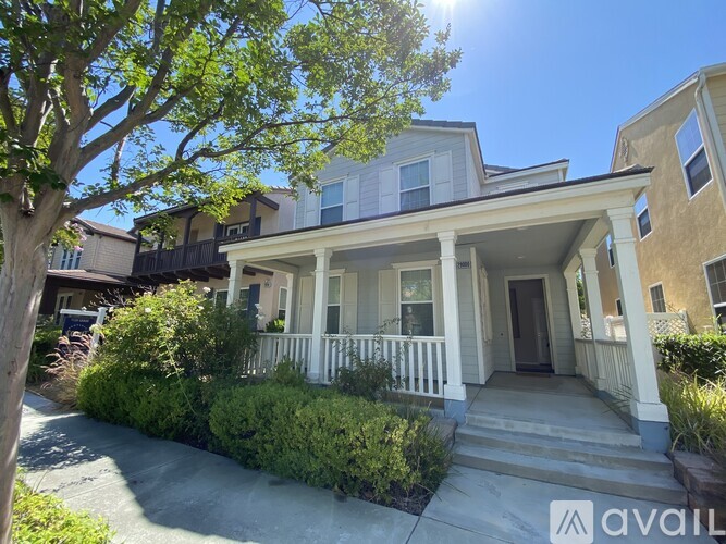 A house with a front porch and a tree in front of it.
