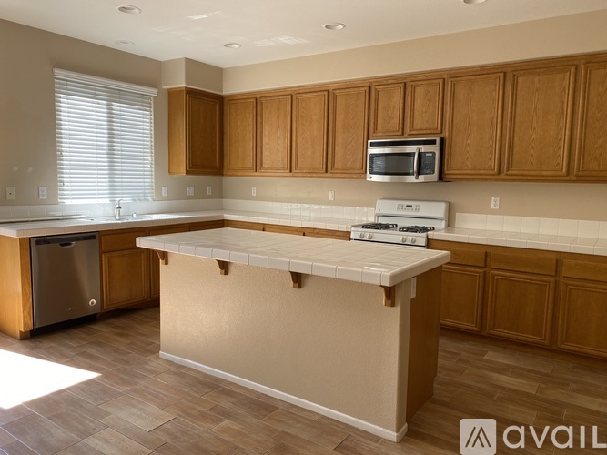 A kitchen with wooden cabinets and a white island.