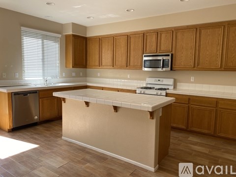 A kitchen with wooden cabinets and a white island.