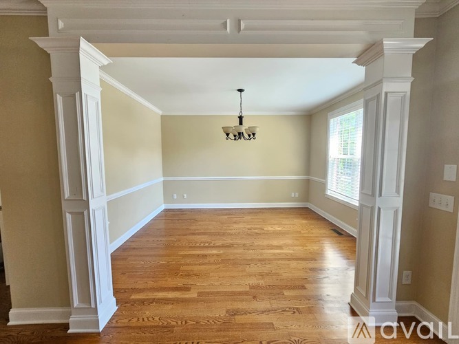 A dining room with a wooden table and chairs.
