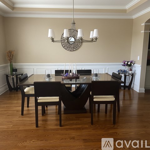 A dining room with a wooden table and chairs.