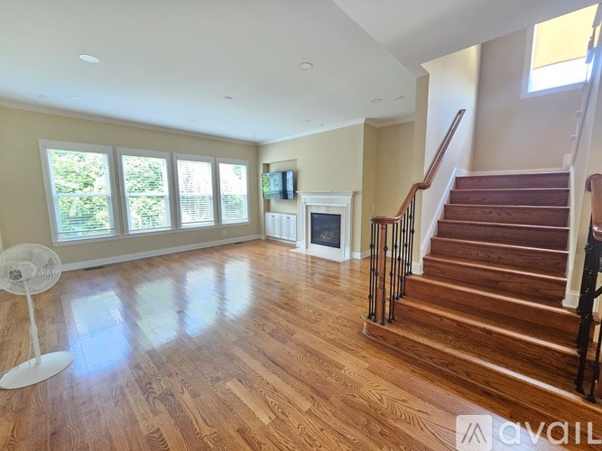 A spacious living room with hardwood floors and a fireplace.