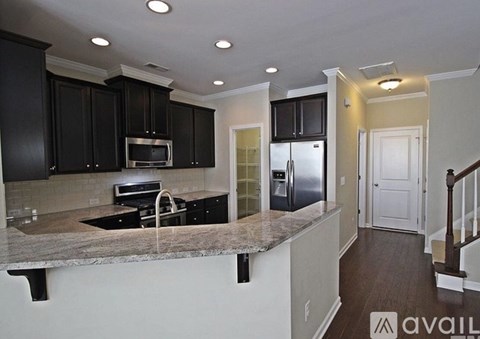 A kitchen with black cabinets and a granite countertop.