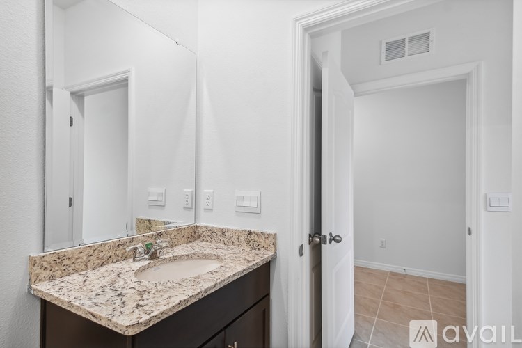 A bathroom with a granite countertop and a sink.