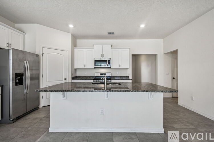 A room with a window covered by white blinds and carpeted floor.