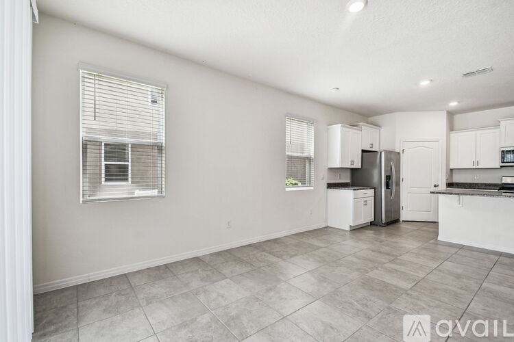 A modern kitchen with granite countertops and a stainless steel sink.