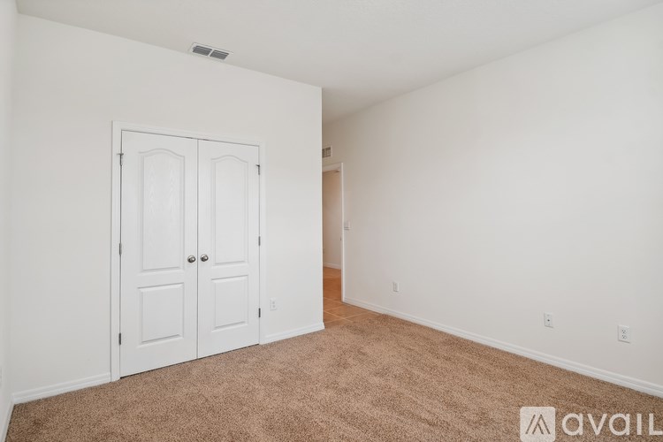 A room with a white door and carpeted floor.