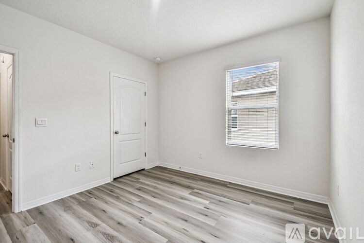A white bathroom with a tub, sink, and window.