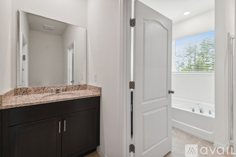A bathroom with a marble countertop and a white door.
