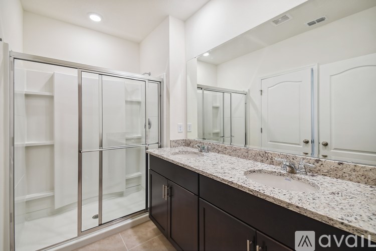 A bathroom with a marble countertop and a walk-in shower.