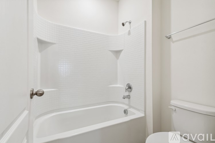 A white bathroom with a tub and toilet.
