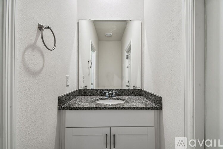 A large empty room with carpeted floor and white walls.