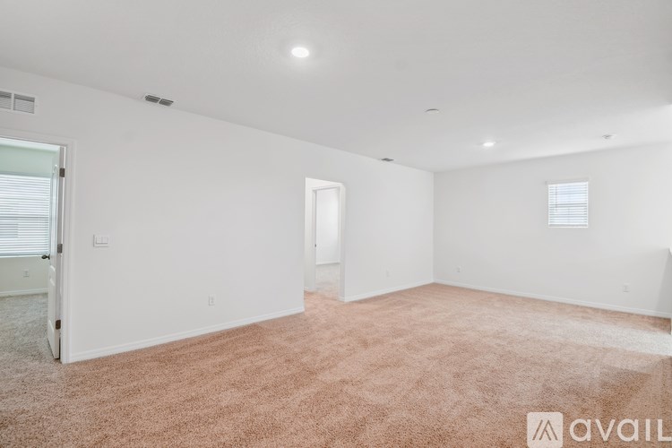 A large, empty room with a carpeted floor and white walls.
