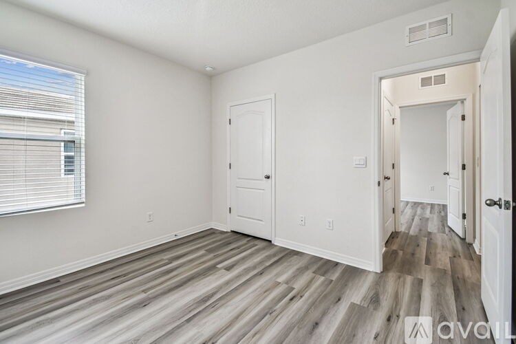A room with wooden flooring and white walls.