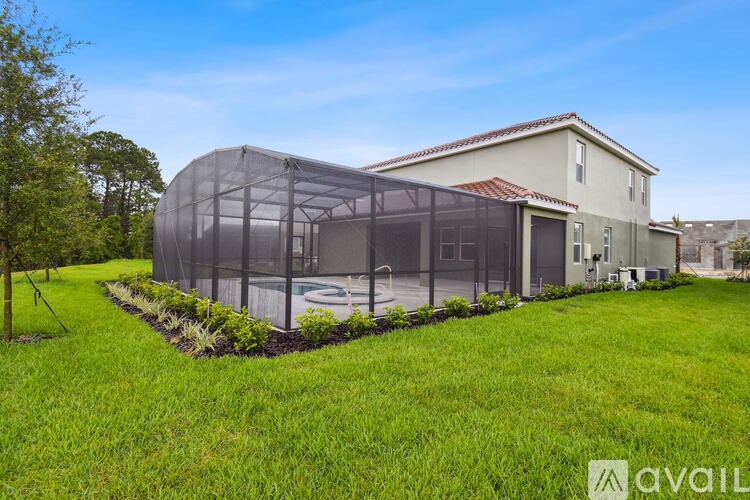 A house with a large glass extension and a well-maintained lawn.