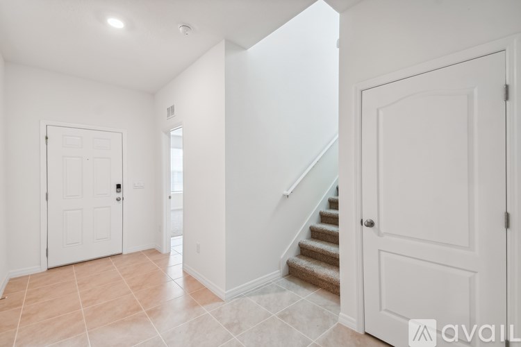 A hallway with a staircase and two doors.