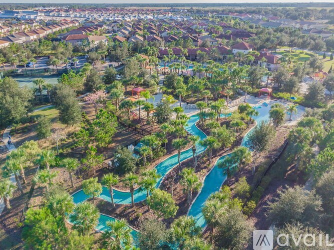 A bird's eye view of a resort with a large pool and surrounding greenery.