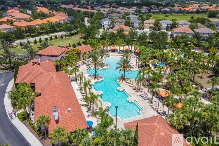 An aerial view of a resort with a pool and palm trees.