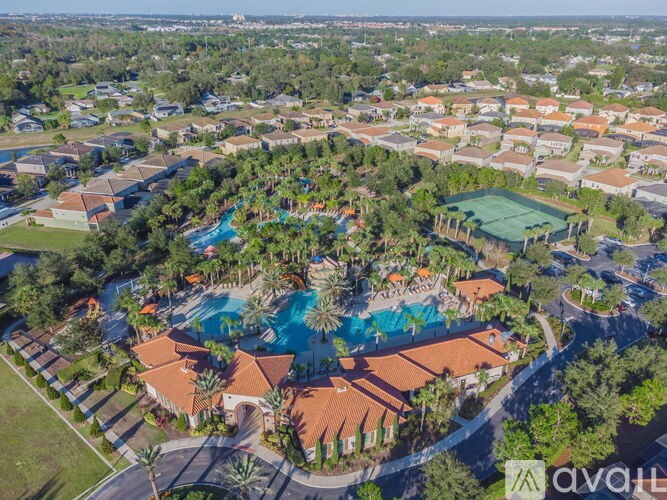 An aerial view of a resort with a swimming pool and palm trees.