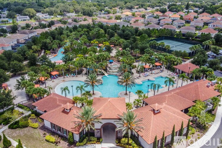 A bird's eye view of a resort with a swimming pool and palm trees.