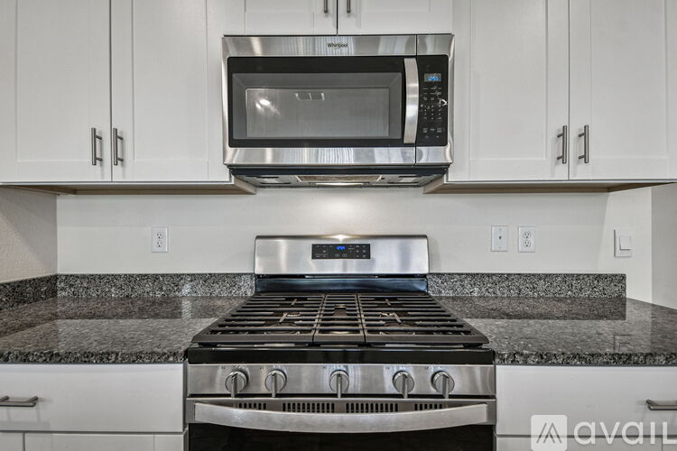 A kitchen with brown cabinets and a marble countertop.
