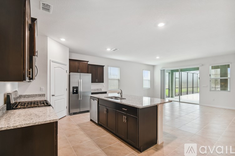 A kitchen with brown cabinets and a marble countertop.