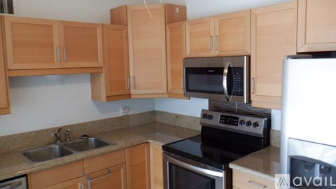 A kitchen with wooden cabinets and a white refrigerator.