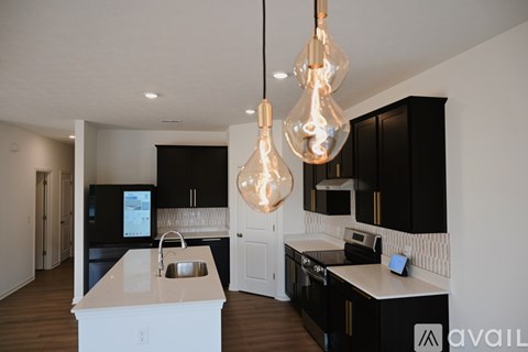 A modern kitchen with black cabinets and a white island.