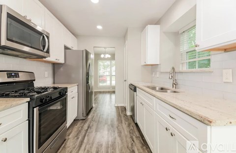 A kitchen with white cabinets and a stainless steel oven.
