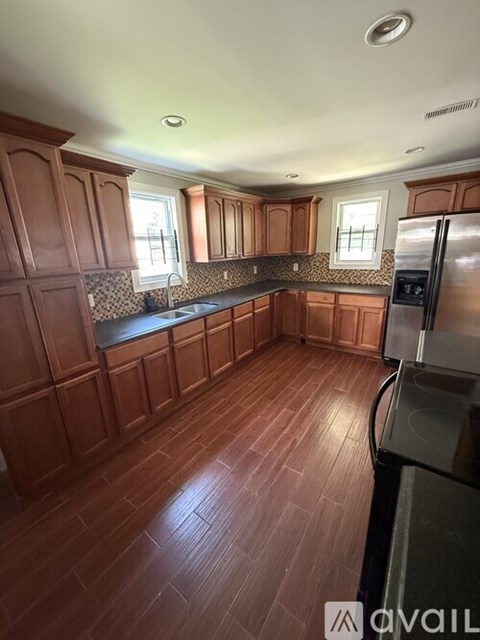 A kitchen with wooden cabinets and a refrigerator.