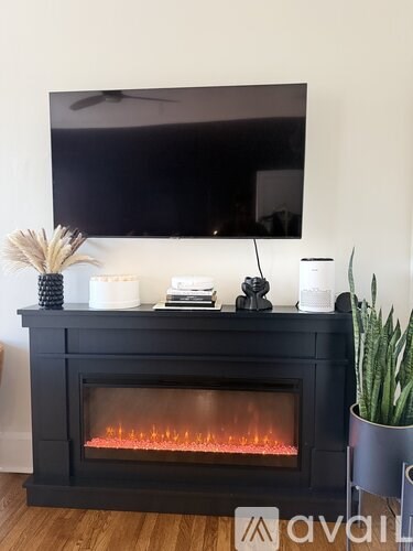 A modern black fireplace with a flat screen TV mounted above it.